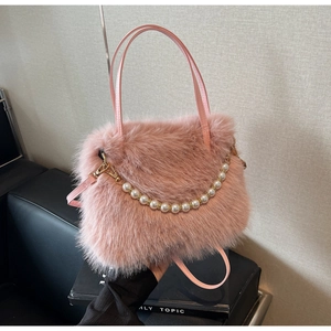 Dettaglio borsa in ecopelliccia rosa con elegante manico di perle e tracolla rimovibile