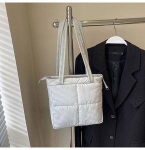 Close-up of light gray quilted puffer tote bag featuring premium fabric and sleek zipper