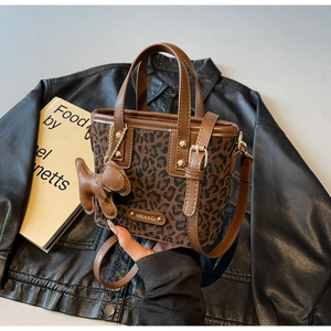 Détail du sac seau léopard avec garniture en cuir marron et breloque chiot mignonne