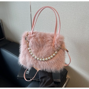 Dettaglio borsa a secchiello in peluche rosa con catena di perle e manico sottile
