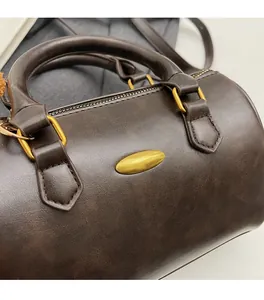 Macro detail of dark brown retro leather texture and bronze D-ring on the Boston bag