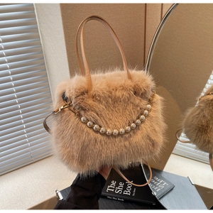 Dettaglio borsa a secchiello in peluche con catena di perle e tracolla in pelle