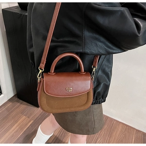Detailed side view of brown patchwork leather handbag with metal handle and shoulder strap