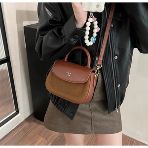 Detailed view of the brown patchwork crossbody bag with PAN TOR logo and shoulder strap