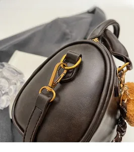 Close-up of vintage brown leather pillow bag with polished gold-tone hardware detail