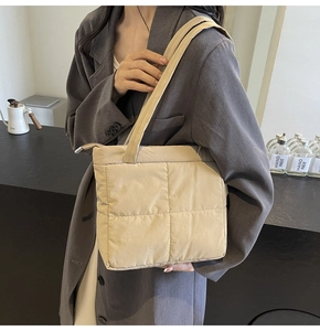 Detail of light beige quilted puffer shoulder bag in waterproof nylon fabric