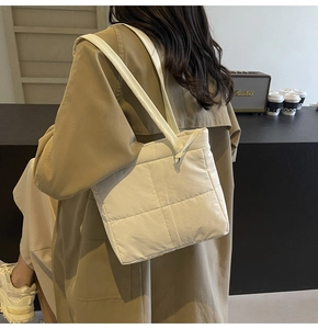 Lifestyle shot of a white quilted tote bag with dual shoulder straps for daily use