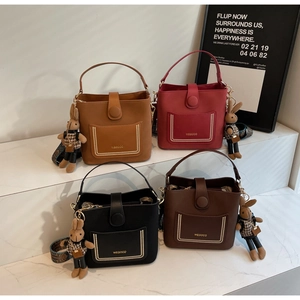 Detail view of retro bucket bags in four colors with floral straps and bunny charms