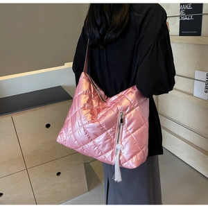 Close-up of pink metallic quilted tote bag with silver zipper and white pompom detail