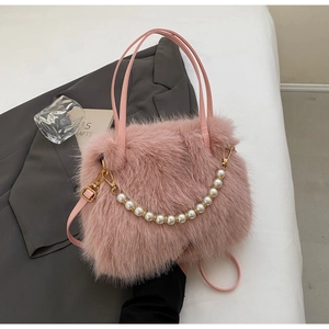 Dettaglio borsa a secchiello in ecopelliccia rosa con catena dorata e perle