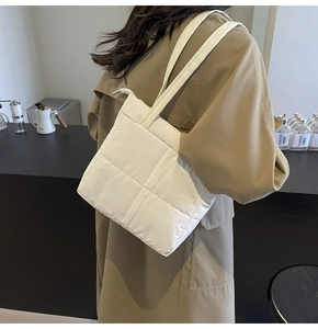 Detail of white quilted nylon shoulder bag showing modern texture and stitching