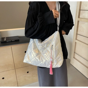 Quilted silver tote bag with tassel detail and geometric pattern shoulder strap