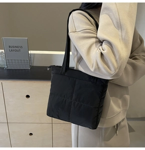 Detail shot of the black quilted shoulder bag featuring premium puffer texture and stitching