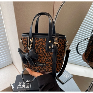 Détail du mini cabas léopard avec bordure en cuir noir et charmant accessoire pour chien