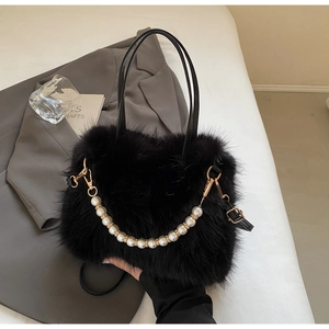 Dettaglio borsa a secchiello in peluche nero con catena di perle su abito grigio