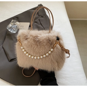 Dettaglio borsa a secchiello in peluche beige con catena di perle e oro metallo