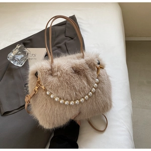 Dettaglio borsa a secchiello in peluche con elegante catena di perle e trama morbida