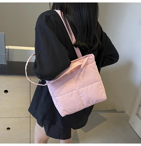 Pink quilted shoulder bag detail showing the lightweight texture and sleek design on a model
