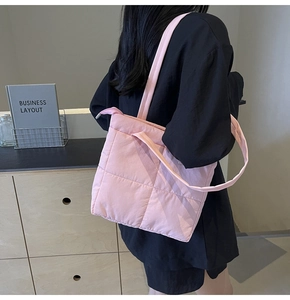Detail of light pink quilted shoulder bag with zipper closure and nylon texture