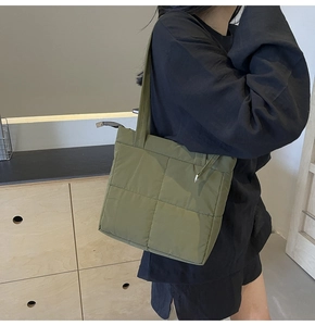 Detail view of military green quilted tote bag with soft padded texture and strap