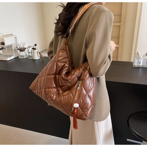 Brown quilted crossbody bag featuring ethnic pattern strap and tassel detail zoom