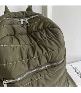 Dettaglio dello zaino in nylon trapuntato verde militare con trama morbida e cerniere