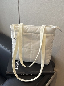 Minimalist white quilted shoulder tote bag with classic square pattern and zip closure