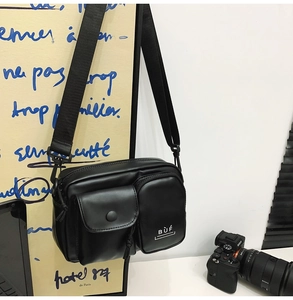 Detail view of the black multi-pocket crossbody phone bag with adjustable strap and BUF logo