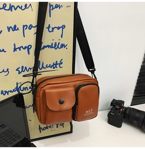 Detailed view of caramel PU leather crossbody bag with multiple front pockets and BUF logo