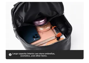 Spacious interior of black pebble leather backpack holding umbrella and essentials