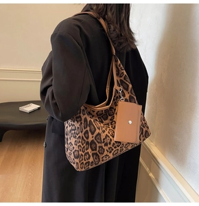 Detail der Leopard-Tragetasche mit braunem Lederriemen und kleiner Clip-Geldbörse