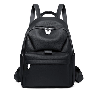 Detail of black pebbled faux leather mini backpack featuring front zipper pocket and top handle
