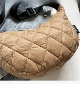 Détail du tissu en nylon matelassé kaki et de la bandoulière réglable du sac à bandoulière