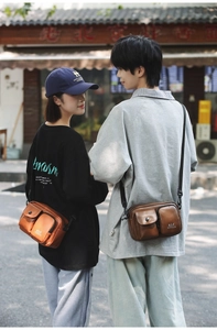 Outdoor street view of models wearing dark brown and tan techwear crossbody bags
