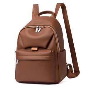 Detail of dark brown lychee textured leather backpack with silver metal zipper pockets