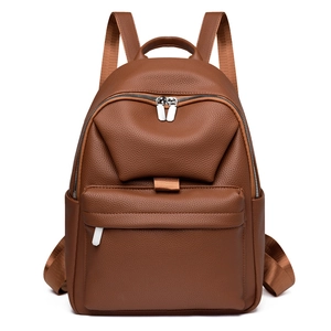 Detail view of brown pebbled leather texture on a stylish women backpack with silver zippers
