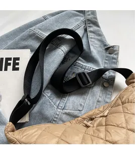 Détail du sac croissant en nylon matelassé beige avec large bandoulière noire