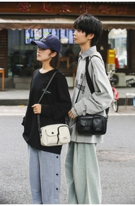 Street style shot of two models wearing black and off-white multi-pocket phone crossbody bags