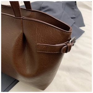 Nahaufnahme der dunkelbraunen Retro-Tasche mit Lederstruktur und silberner Schnalle