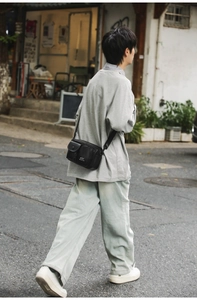 Close-up of a black multi-pocket crossbody bag with adjustable wide strap for daily wear
