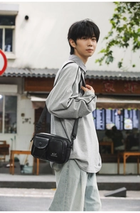 Close-up of black tactical crossbody phone bag with adjustable nylon strap on a male model