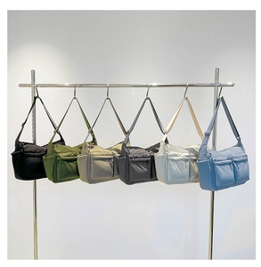 Sacs bandoulière en nylon matelassé en plusieurs couleurs sur un cintre en métal