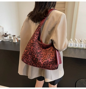 Details der Leopard-Print-Tasche und der tiefroten Ledergriffe an einem Model
