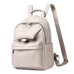 Detailed side view of the cream leather backpack showing its pebble grain and zipper pocket