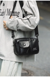 Detail of black crossbody techwear bag featuring multi-pocket design and adjustable strap