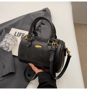 Detail of vintage Boston handbag with matte leather texture and retro gold hardware
