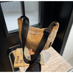 Détail du sac bandoulière matelassé en nylon kaki avec sangle réglable et étiquette noire