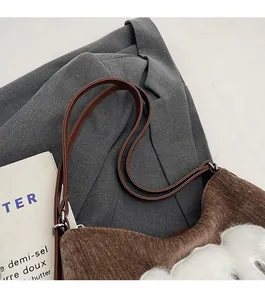 Détails des bretelles confortables et texture en velours côtelé marron du sac