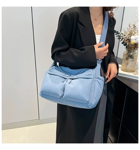 Sac bandoulière en nylon bleu clair avec plusieurs poches porté par un mannequin