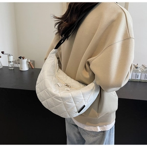 Détail du sac demi-lune en nylon blanc matelassé avec surpiqûres losanges et bandoulière